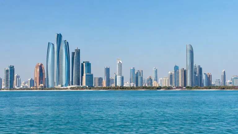 The Abu Dhabi skyline along the Corniche with the sea in the foreground on a clear morning