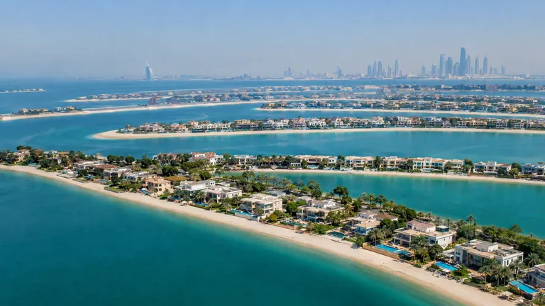 Waterfront villas with private beaches on a palm-shaped island in Dubai seen from the air