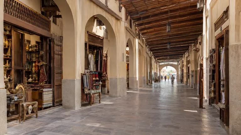 A traditional covered souk arcade in Sharjah with arched walkways and small shopfronts, no readable signs