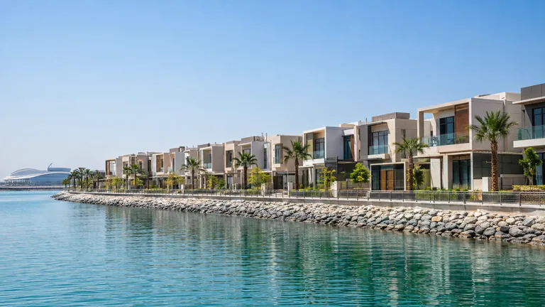 Rows of new townhouses beside a waterway on Yas Island in Abu Dhabi under a clear sky
